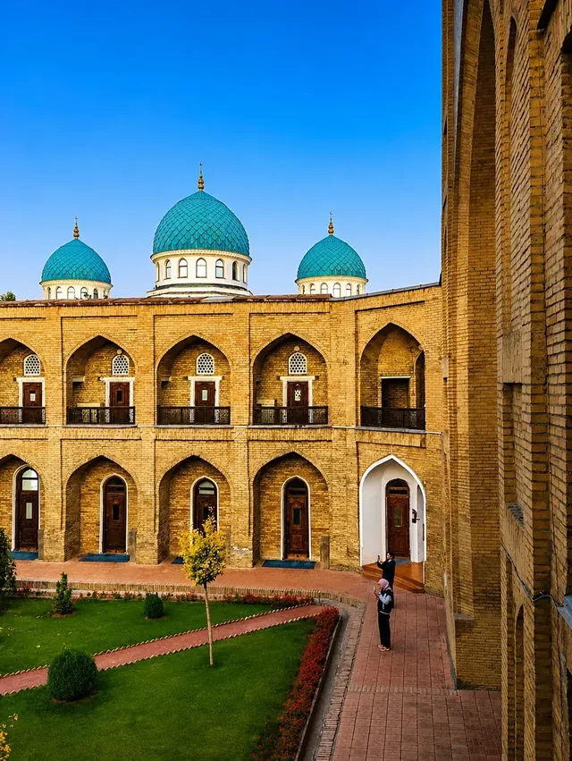 Historisch gebouw met turquoise koepels en een groene binnentuin in Oezbekistan