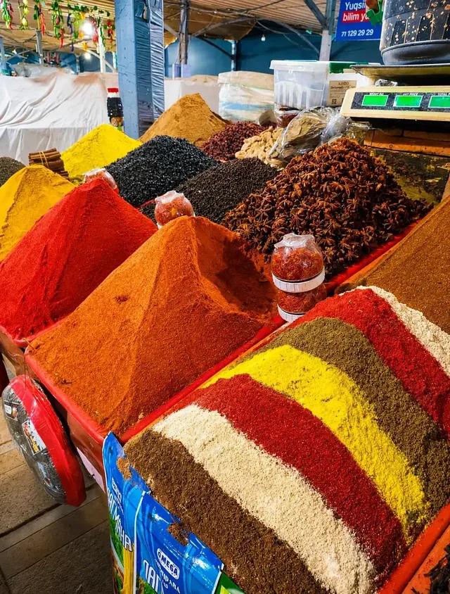 Kleurrijke specerijen opgestapeld op een marktkraam in Tasjkent